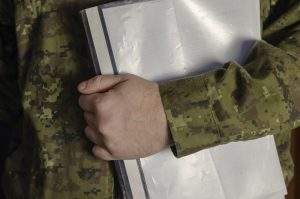 An officer is holding a plastic folder of documents