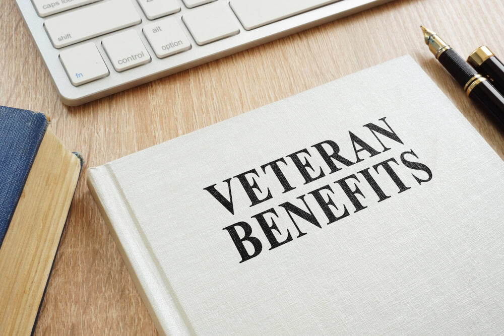 Book titled Veteran Benefits on desk representing VA backlog issues and delayed disability claims.