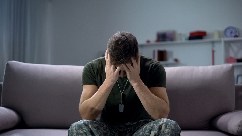 Nervous male military suffering depression, sitting alone at home
