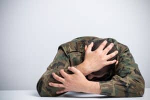 Veteran in distress due to migraine pain connected to VA disability benefits for migraines.
