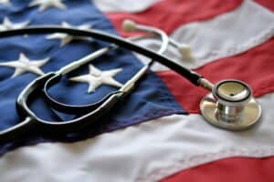 Agent Orange exposure and aggressive bone marrow cancers concept with medical stethoscope on American flag.