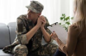 Veteran speaking with a healthcare professional during an evaluation, representing VA benefits for tinnitus.