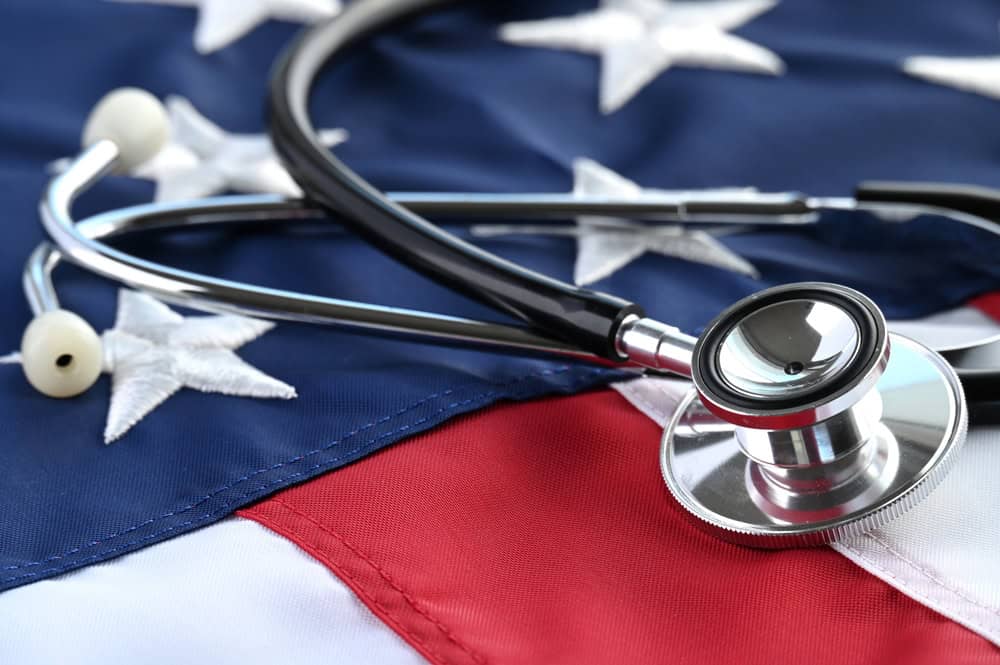 Stethoscope resting on an American flag, representing healthcare and VA disability rates.