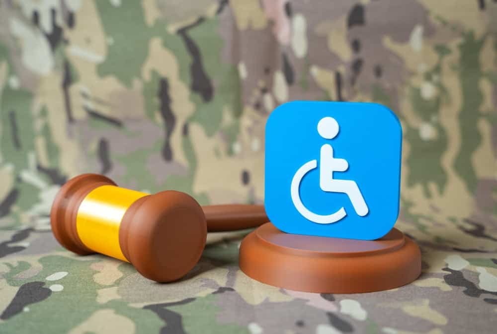 A disability access symbol and judge’s gavel on a military uniform background, symbolizing legal decisions affecting disability benefits.